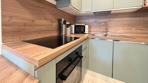 A modern kitchen with wooden countertops, a built-in microwave, and stainless steel appliances. - Eur Home Clusone (Clusone)