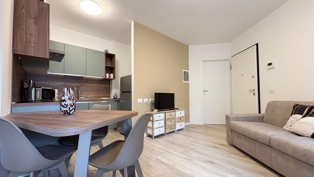 A modern apartment with a kitchen, dining area, and living room. - Eur Home Clusone (Clusone)