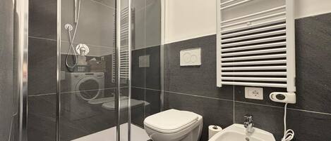 Regadera, secadora de cabello, bidet, toallas