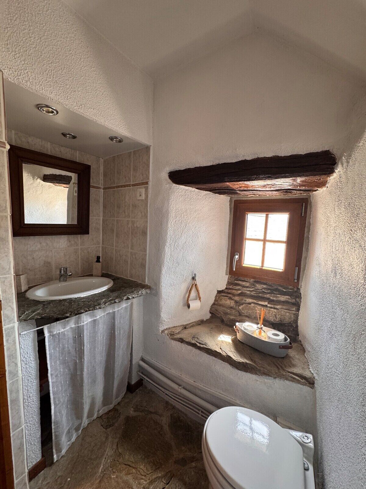 A bathroom with a sink, mirror, and toilet.