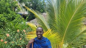 A person standing in a garden with a tiled floor and various plants. - 64 ZENJ HOUSE (Zanzibar Town)