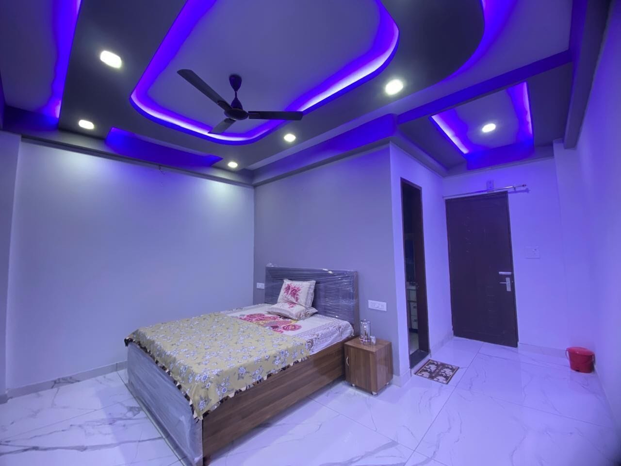 Un dormitorio con cama, ventilador de techo y puerta.