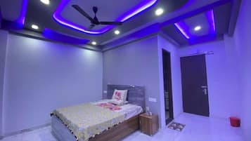 Un dormitorio con cama, ventilador de techo y puerta.