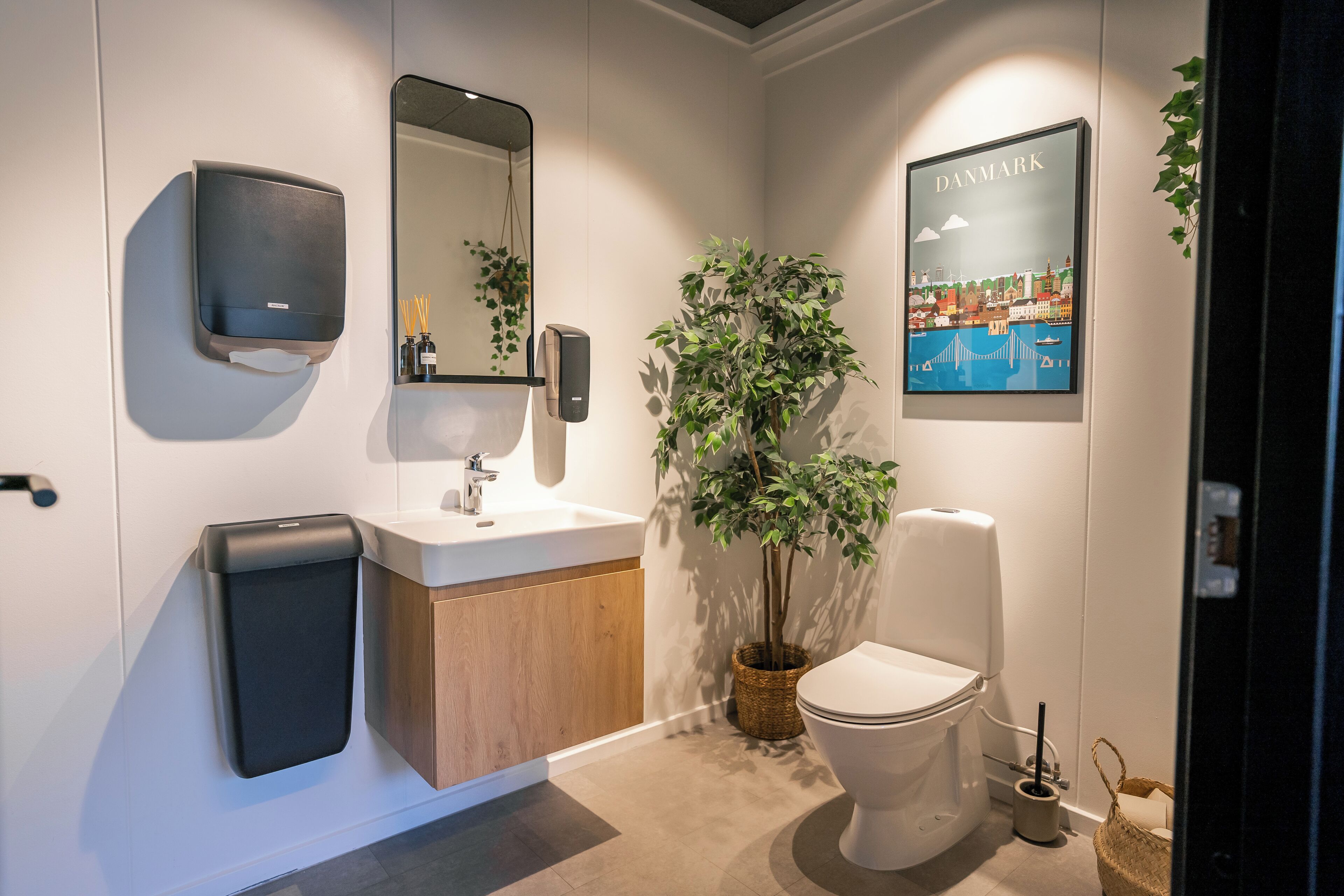 Ein modernes Badezimmer mit Toilette, Waschbecken und Spiegel.