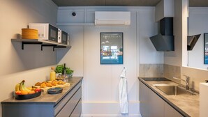 Une cuisine moderne dotée d’appareils électroménagers intégrés, d’un évier et d’un plan de travail sur lequel sont disposés des fruits et des pâtisseries.