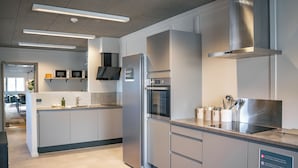 Une cuisine moderne équipée d’appareils électroménagers en acier inoxydable, d’un four encastré et d’un four à micro-ondes.
