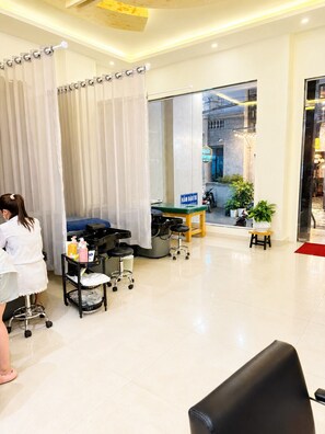 A clean, modern room with a large window, a reception desk, and a sign indicating a massage service. - Lien's 2 Hotel Da Lat (Da Lat)