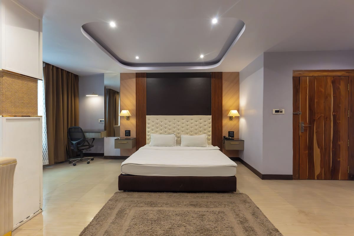 Habitació d'hotel moderna amb un llit gran, una taula de treball i una cadira.