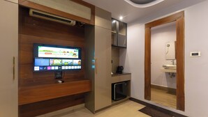 Una cocina moderna con electrodomésticos integrados, un televisor de pantalla plana y un refrigerador pequeño.