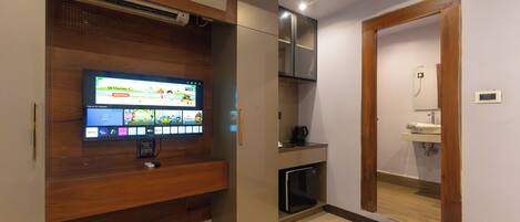 Een moderne keuken met inbouwapparatuur, een flatscreen televisie en een kleine koelkast.