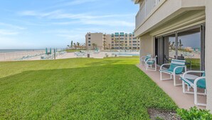 Un hotel con piscina, mobiliario exterior y vistas al océano.
