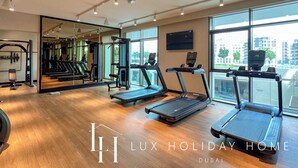 Ein modernes Fitnessstudio mit Laufbändern, Kraftgeräten und einem großen Spiegel.