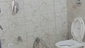 A bathroom with a toilet, bidet, and a small stool. - Mango Bite Hotel & Restaurant (Mandvi)