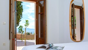 Een slaapkamer met een bed, een raam en een spiegel.