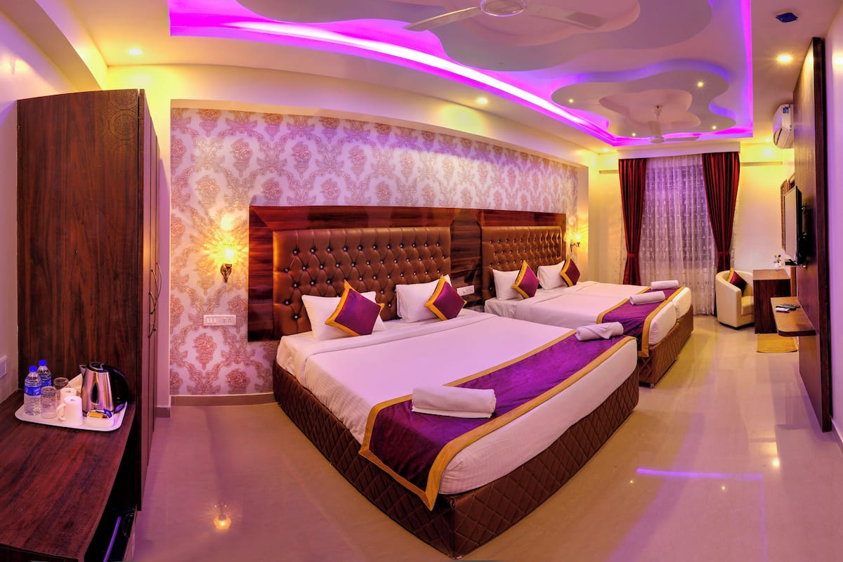 A hotel room with a large bed, a desk with amenities, and a TV.