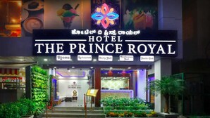 The exterior of Hotel The Prince Royal with a sign indicating Rooms, Restaurant, Party Hall, Conference Hall, and Health Club. - Hotel The Prince Royal  (Bengaluru)