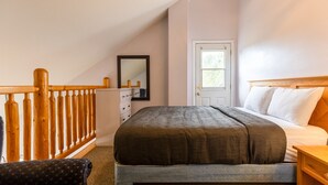 A bedroom with a bed, a dresser, a mirror, and a door. - 5 Mins from the Resort | Sleeps 3 | Dog Friendly (Fernie)