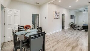 Un vaste espace de vie comprenant une table à manger, des chaises et un ventilateur de plafond.