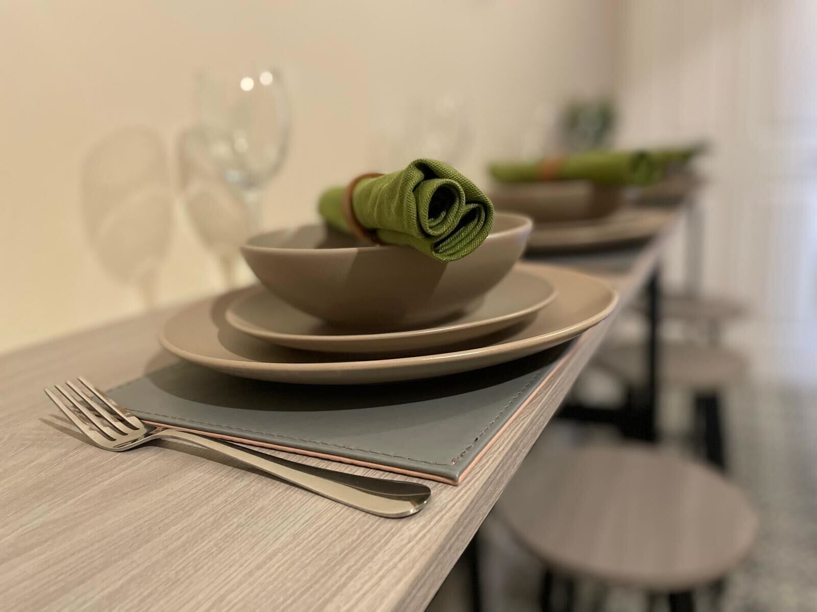 A neatly set dining table with plates, bowls, and a fork.