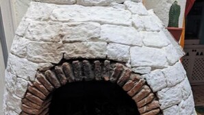 A stone-built outdoor oven with a brick interior, surrounded by a white wall. - RIAD MEDINA (Essaouira)