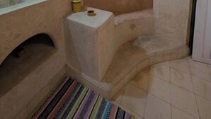 A bathroom with a bathtub, a sink, and a mirror. - RIAD MEDINA (Essaouira)