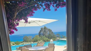 A patio with a table and chairs, overlooking a pool and the sea. - Charming villa just 10 minutes (800m) walk from Palombaggia Beach (Porto-Vecchio)