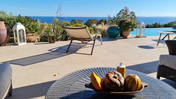 A patio with a view of the ocean, a table with a bowl of fruit, and outdoor furniture. - Charming villa just 10 minutes (800m) walk from Palombaggia Beach (Porto-Vecchio)