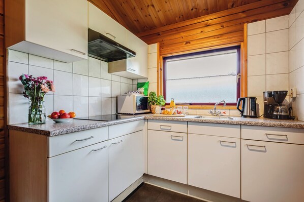 Refrigerador, placa de cocina, cafetera/tetera, mesa de comedor