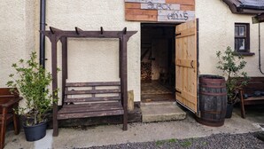 A rustic building with a wooden pergola and a sign that reads "The Black Bulls." - Rusty Barn (Limavady)
