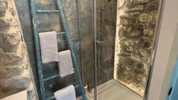 Een douche, handdoeken, toiletpapier