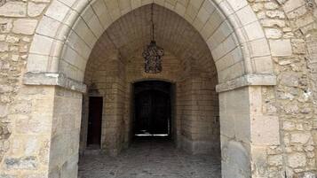 A stone archway leading into a building with a cobblestone floor.