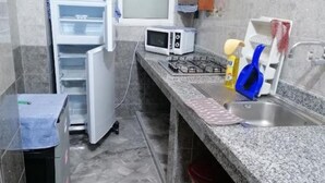A compact kitchen with a built-in microwave, a gas stove, and a sink. - Furnished apartment with 2 bedrooms, kitchen, bathroom and living room (Meknès)
