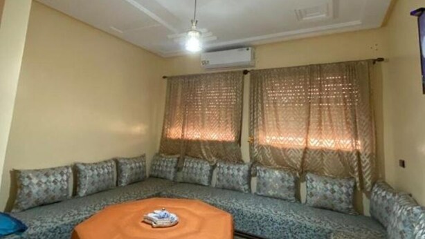 A living room with a sofa set, a coffee table, and an air conditioning unit on the wall. - Furnished apartment with 2 bedrooms, kitchen, bathroom and living room (Meknès)