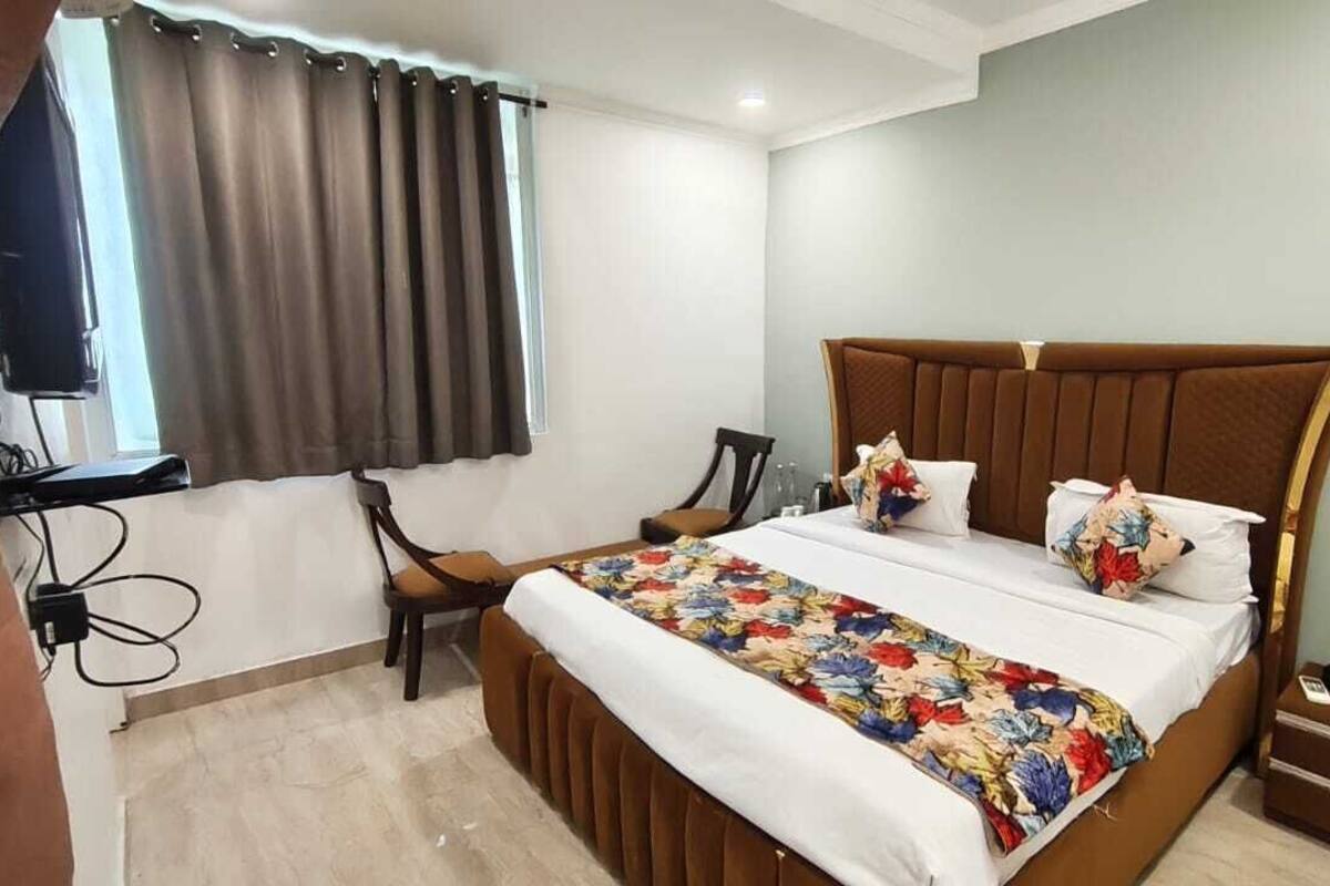A bedroom with a large bed, a desk, and a chair.