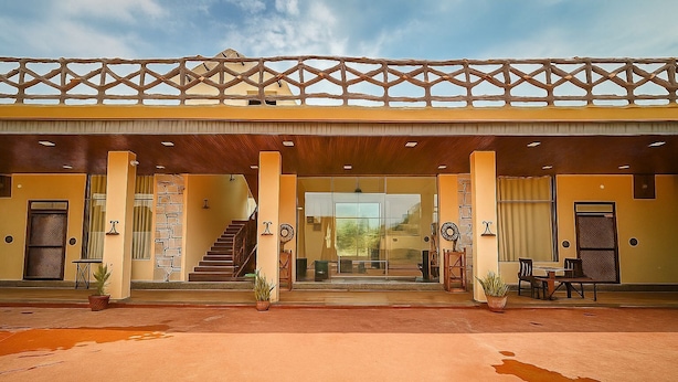 A hotel entrance with a covered walkway, a staircase, and potted plants.