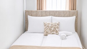 A neatly made bed with a beige bedspread, white pillows, and a patterned pillow. - Cozy Central 8BR Apt w/Garden & Terrace, Up to 16P (Vienna)