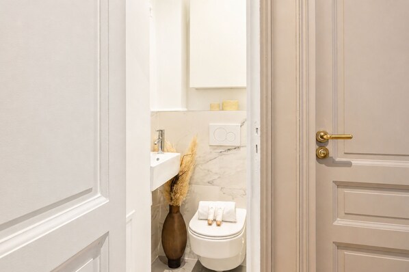 A bathroom with a toilet, a sink, and a cabinet.