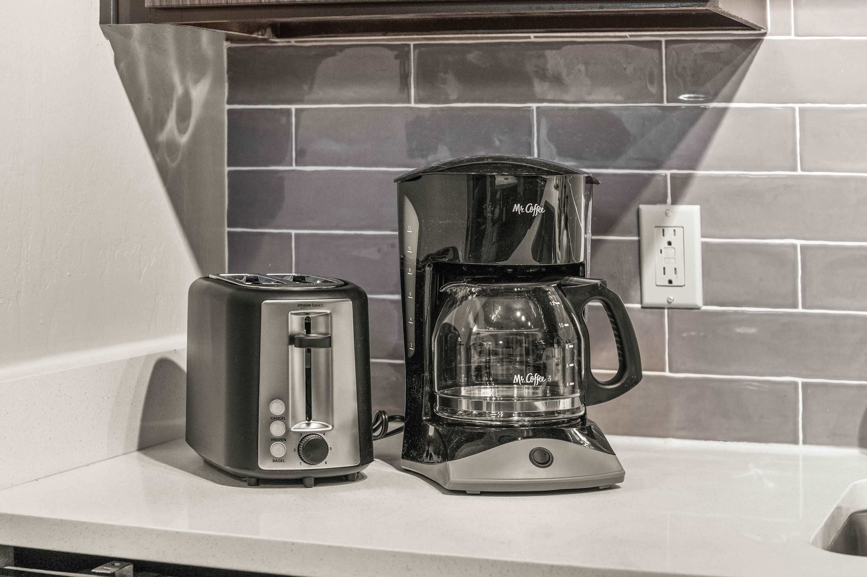 A kitchen counter with a toaster and a coffee maker.