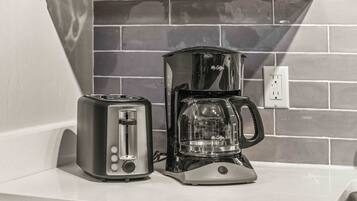 A kitchen counter with a toaster and a coffee maker.