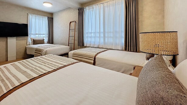 A hotel room with two beds, a TV, a lamp, and a window with curtains. - Viento Ikebukuro (Tokyo)