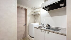 A compact kitchen with a built-in refrigerator, a sink, and a stove. - Viento Ikebukuro (Tokyo)