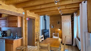 A wooden interior with a kitchen, dining area, and a fireplace. - Chalet on the edge of town, close to the Balme cable car (La Clusaz)