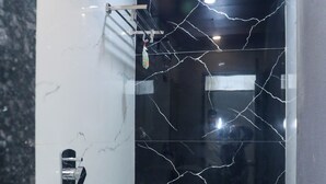 Um banheiro compacto com pia branca, vaso sanitário e chuveiro.