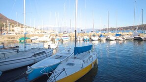 A marina with various boats docked, calm water, and a clear sky. - Charming villa with private garden and AC in Salo', few steps away from the lake (Salò)