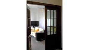 A hotel room with a bed, a TV, and a window with curtains. - Charming villa with private garden and AC in Salo', few steps away from the lake (Salò)