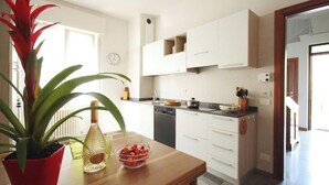A modern kitchen with white cabinets, a wooden countertop, and a potted plant. - Charming villa with private garden and AC in Salo', few steps away from the lake (Salò)