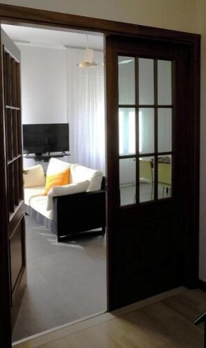 Une chambre d’hôtel avec un lit, une télévision et une fenêtre avec des rideaux.