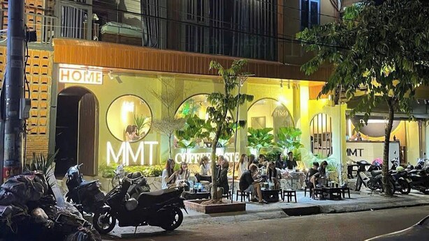 A building with a cafe named "MMT Coffee House" and a sign reading "HOME". - MMT Homestay (Can Tho)