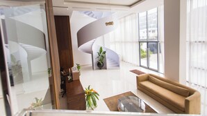 Un intérieur moderne avec un escalier à volutes, un canapé et une table basse.