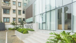 Un bâtiment moderne, sur lequel on peut lire l’inscription « ESSENCE », et un chemin pavé qui mène à un escalier.